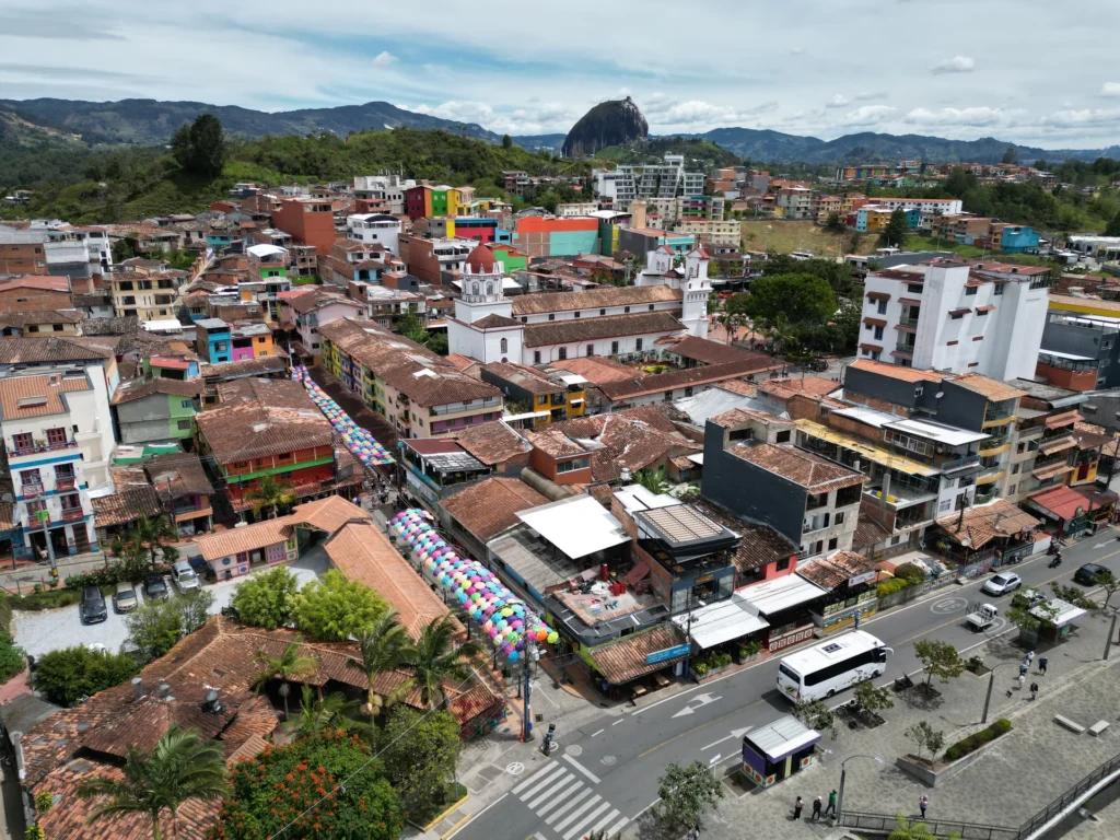 Aerial view of Guatapé with La Piedra rising behind the colourful town