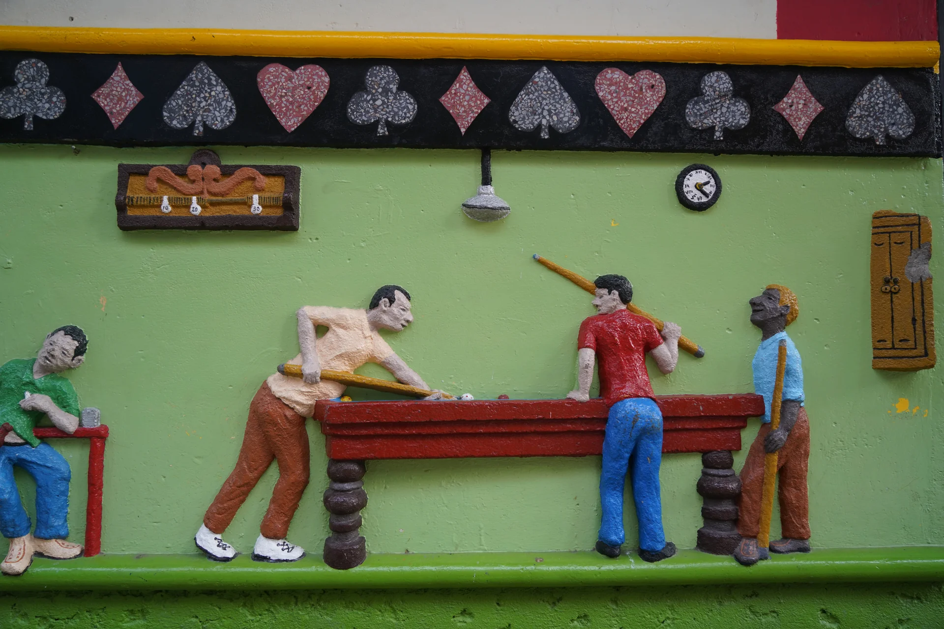Zócalo 3D relief art depicting local billiards hall — everyday social life in Guatapé