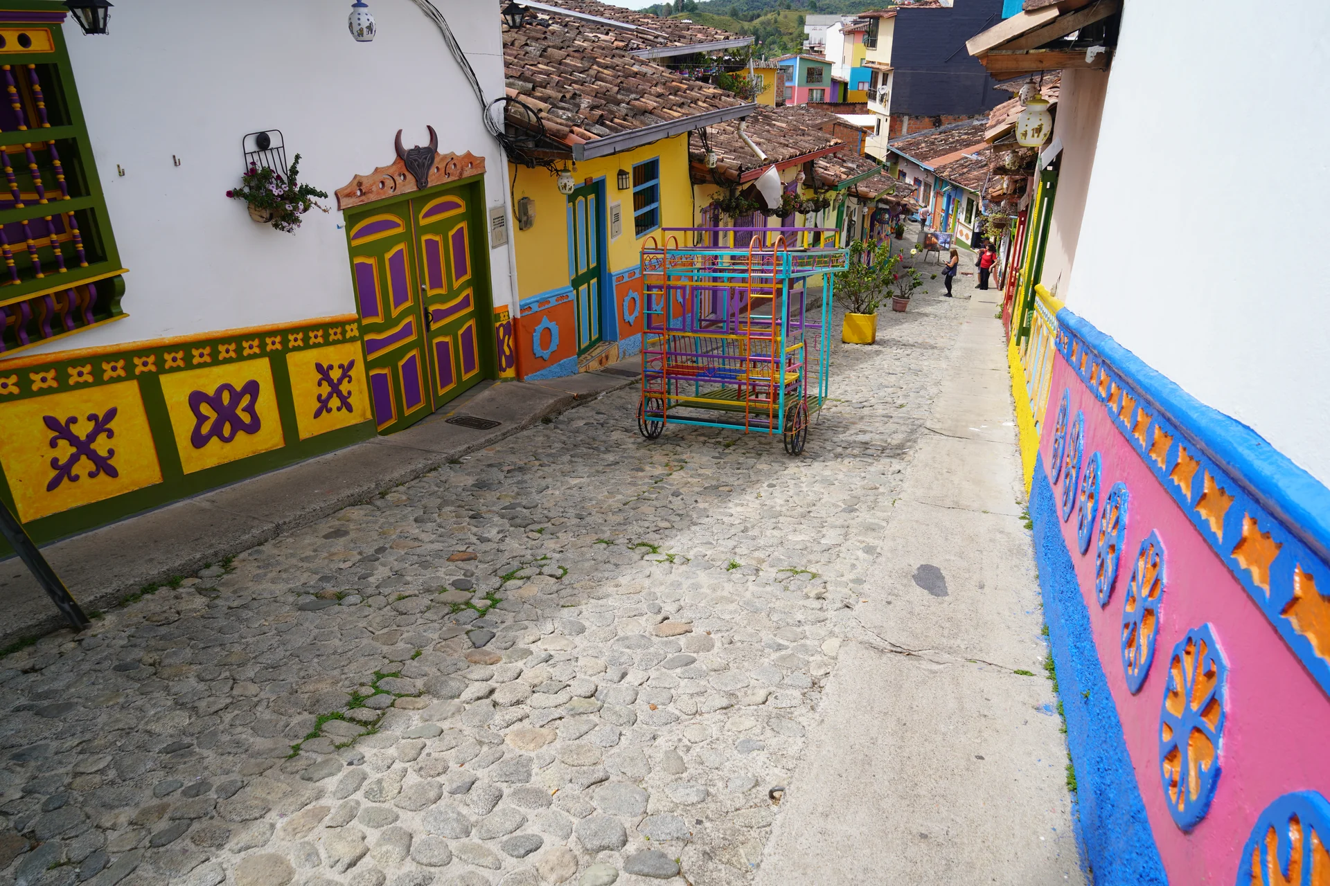 Empty cobblestone street lined with vibrantly painted zócalo houses, Guatapé