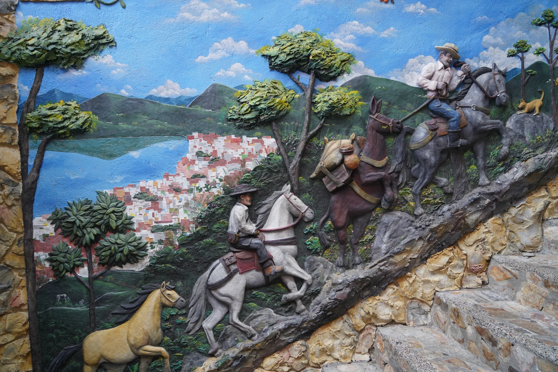 Zócalo panel — Colombian cowboys on horseback with the Guatapé reservoir behind