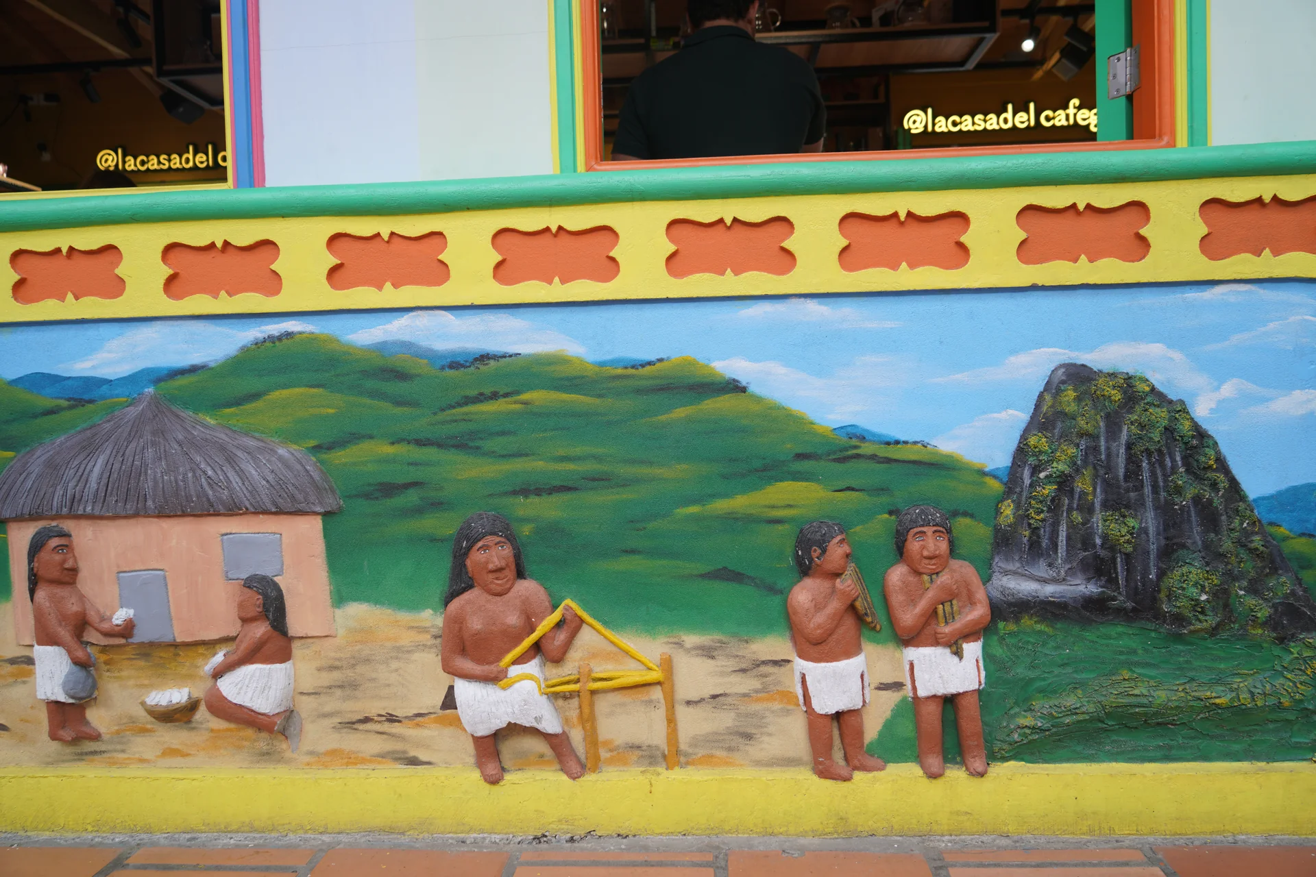 Tahamí figures in traditional dress, zócalo art Guatapé Colombia